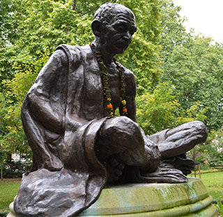 A statue of an elderly gentleman, with his head bowed and his legs crossed beneath him. A statue of an elderly gentleman, with his head bowed and his legs crossed beneath him.