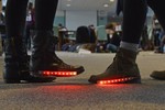 Two women are wearing light up boots with red lights on them.